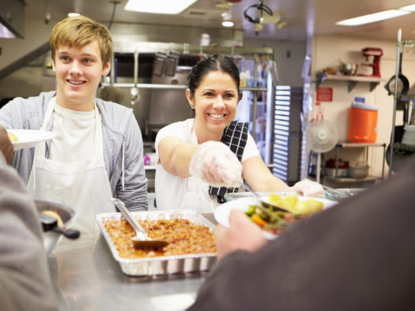 People serving food at a homeless shelter