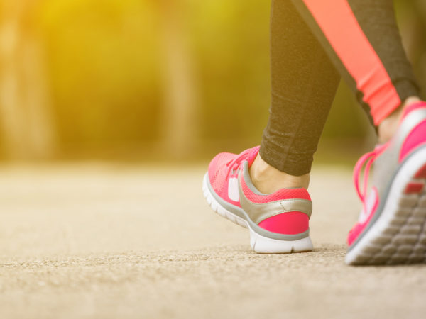 View of a woman's athletic shoes as she's running in a park