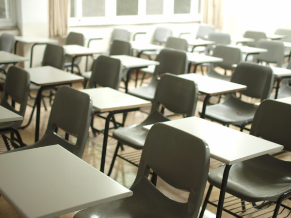 Et klasseværelse fyldt med skriveborde og stole