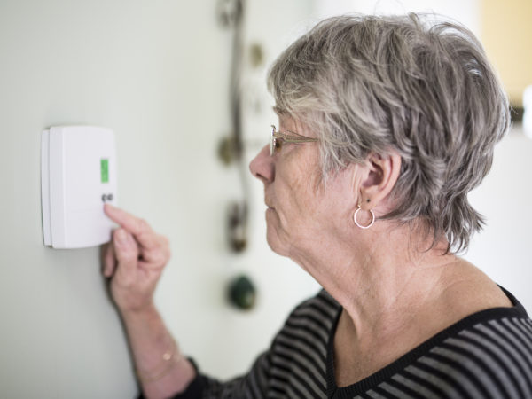 senior person checking thermostat