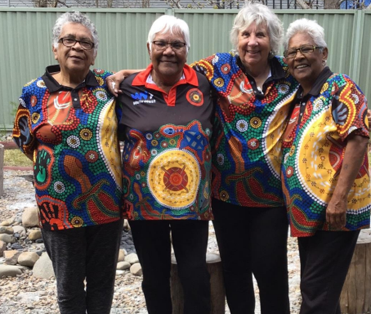 En grupp av fyra aboriginska kvinnor i traditionell klädsel.