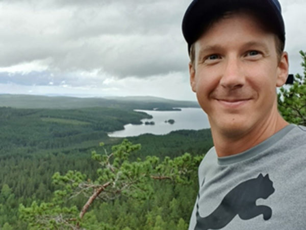 Björn Ahnell smiling at the top of a mountain