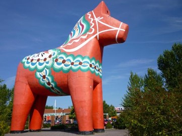 An oversized decorative horse model towering over small buildings