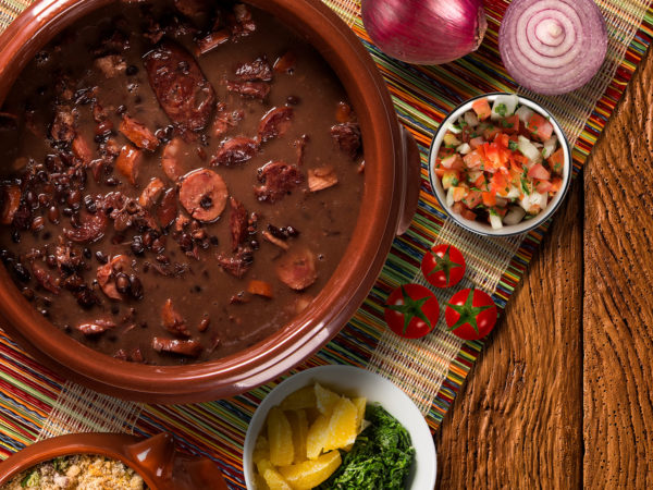 A bowl filled with feijoada, including beans and meats