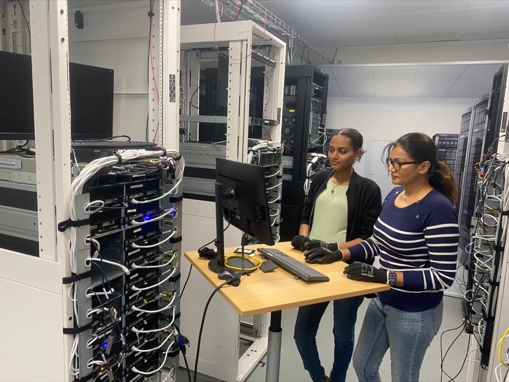 Kaksi naista seisoo tietokoneen ääressä Datacenter Academyn tiloissa