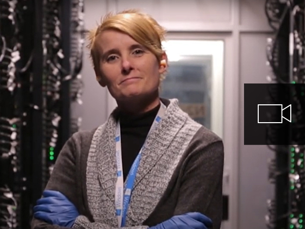 Een vrouw staat tussen servers in een datacenter