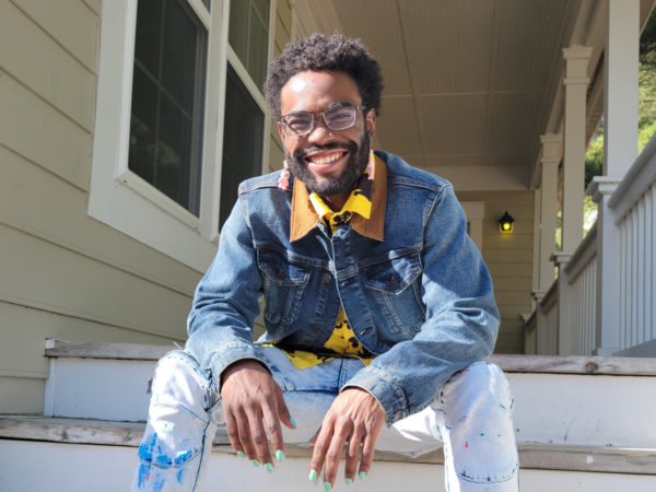 Abdullah Bell, sitting on the steps of a front porch