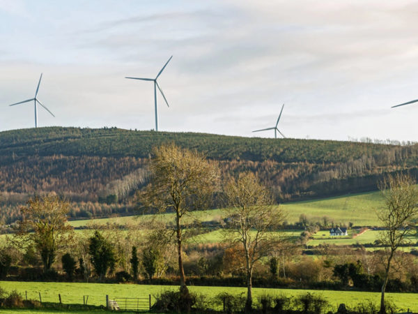 Turbiny wiatrowe na wzgórzu w wiejskiej miejscowości rolniczej