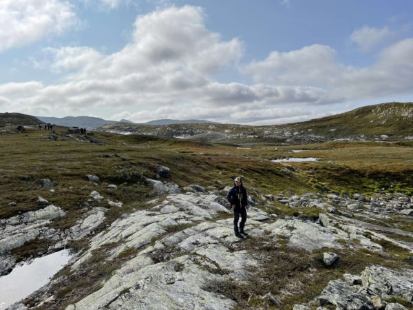 Elliot står på store klippestykker på en øde bjergskråning