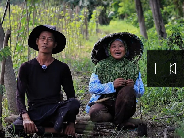 Two farmers sitting in the shade on a farm in Indonesia