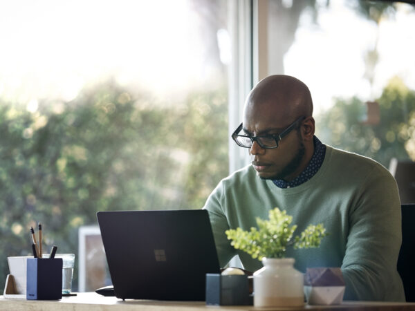 Afroamerikansk/svart man som arbetar med en bärbar dator