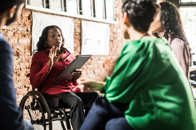 一位坐在輪椅上的女性正與另外三個人交談