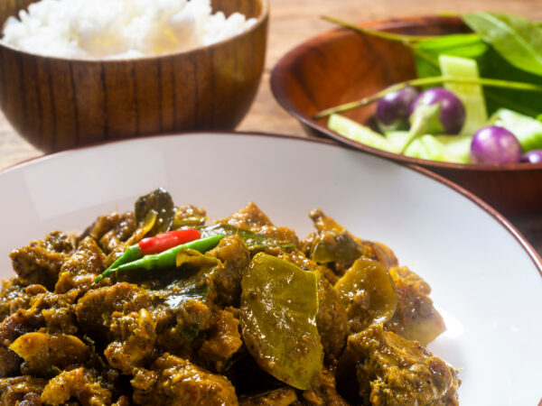 Kryddig anka i curry på ett träbord. Redo att äta.