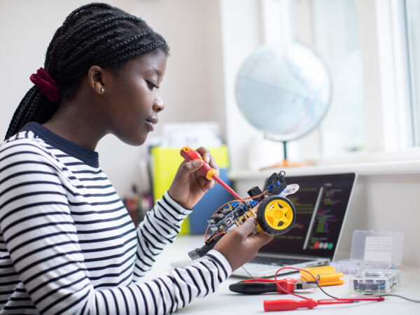 Female Teenage Pupil Building Robot Car in STEM lesson
