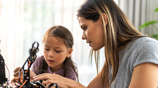 A woman teaching a girl about STEM