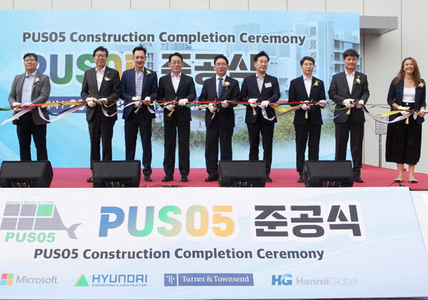 A group of people standing at a ribbon cutting ceremony