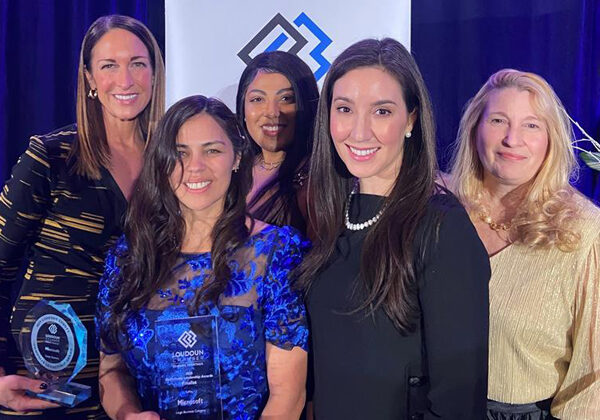 Five women standing with an award