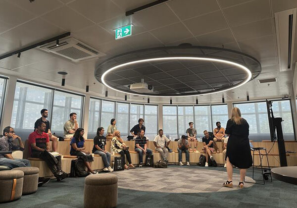 People sitting in an auditorium listening to a speaker