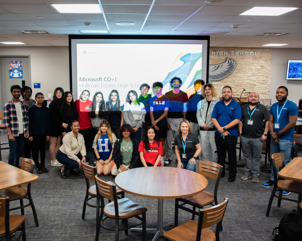 A large group of teens standing in a classroom in front of a projector