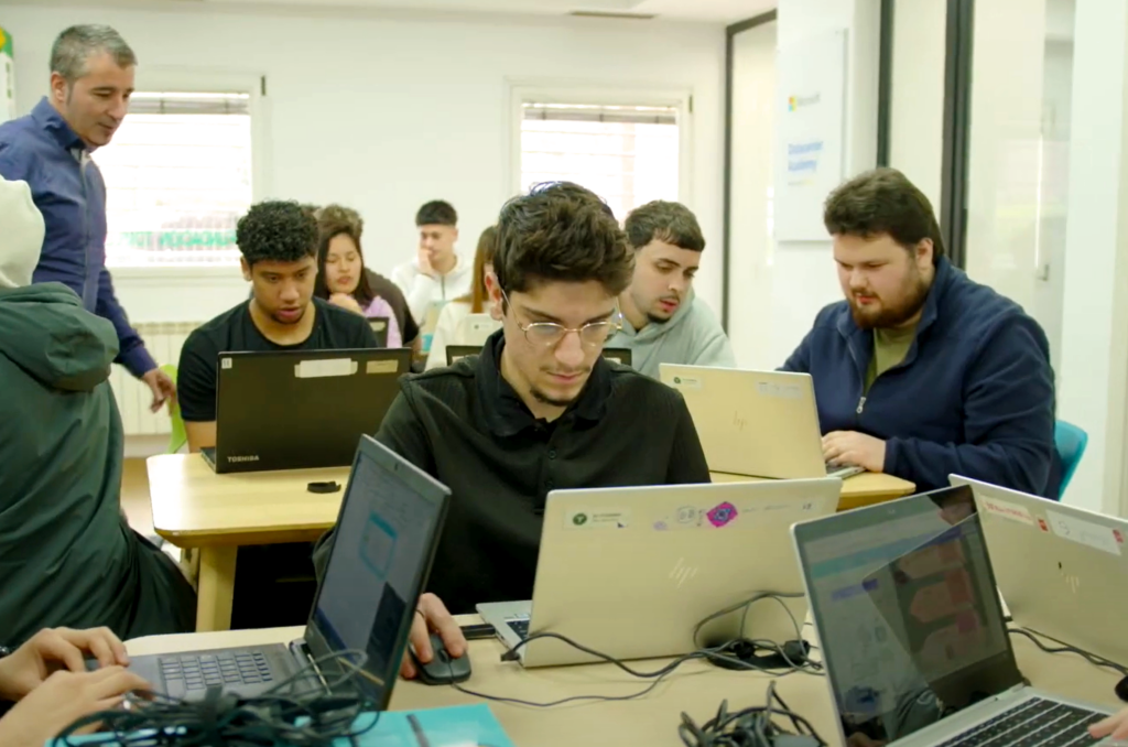 Several students at the Microsoft Datacenter Academy in Madrid working on laptops in a classroom as they pursue training for datacenter careers