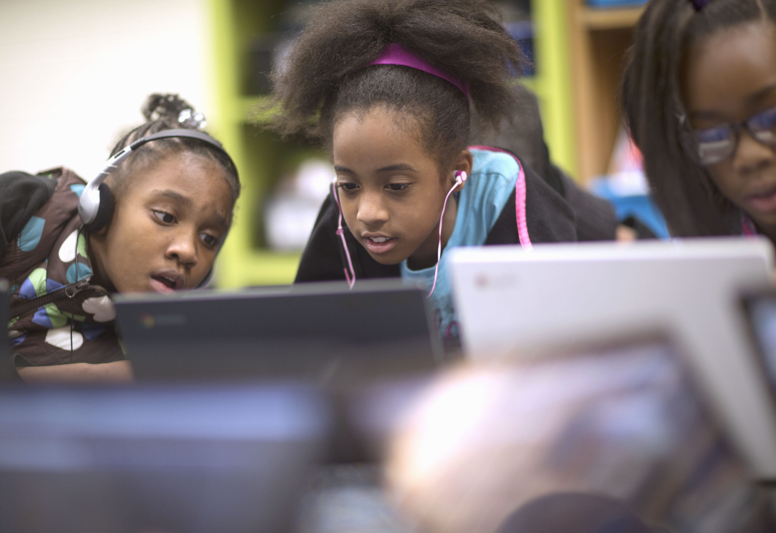 Three 11 year old girls work together on computers
