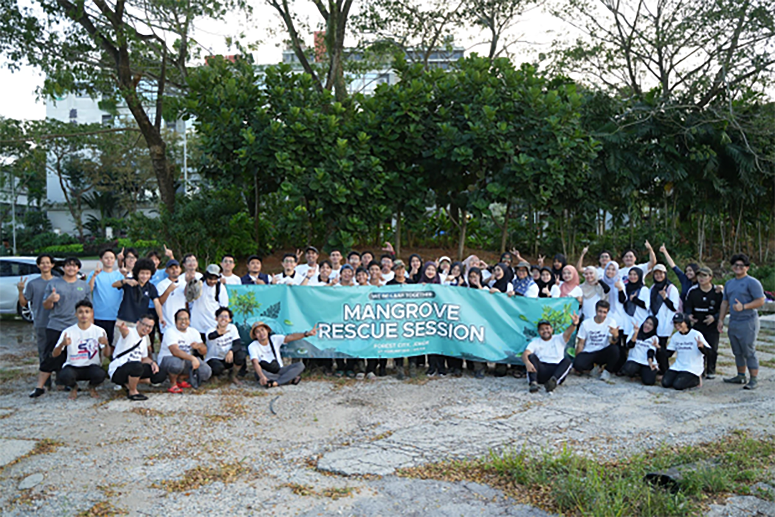 A large group of people holding up a sign that reads "Mangrove Rescue Session"
