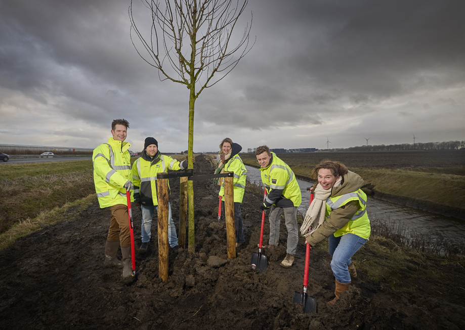 Five people planting a tree at Agriport Middenmeer