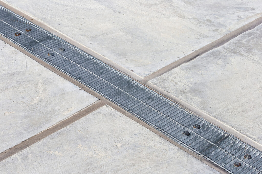 Metal rainwater collection grid in a car parking areas with concrete flooring