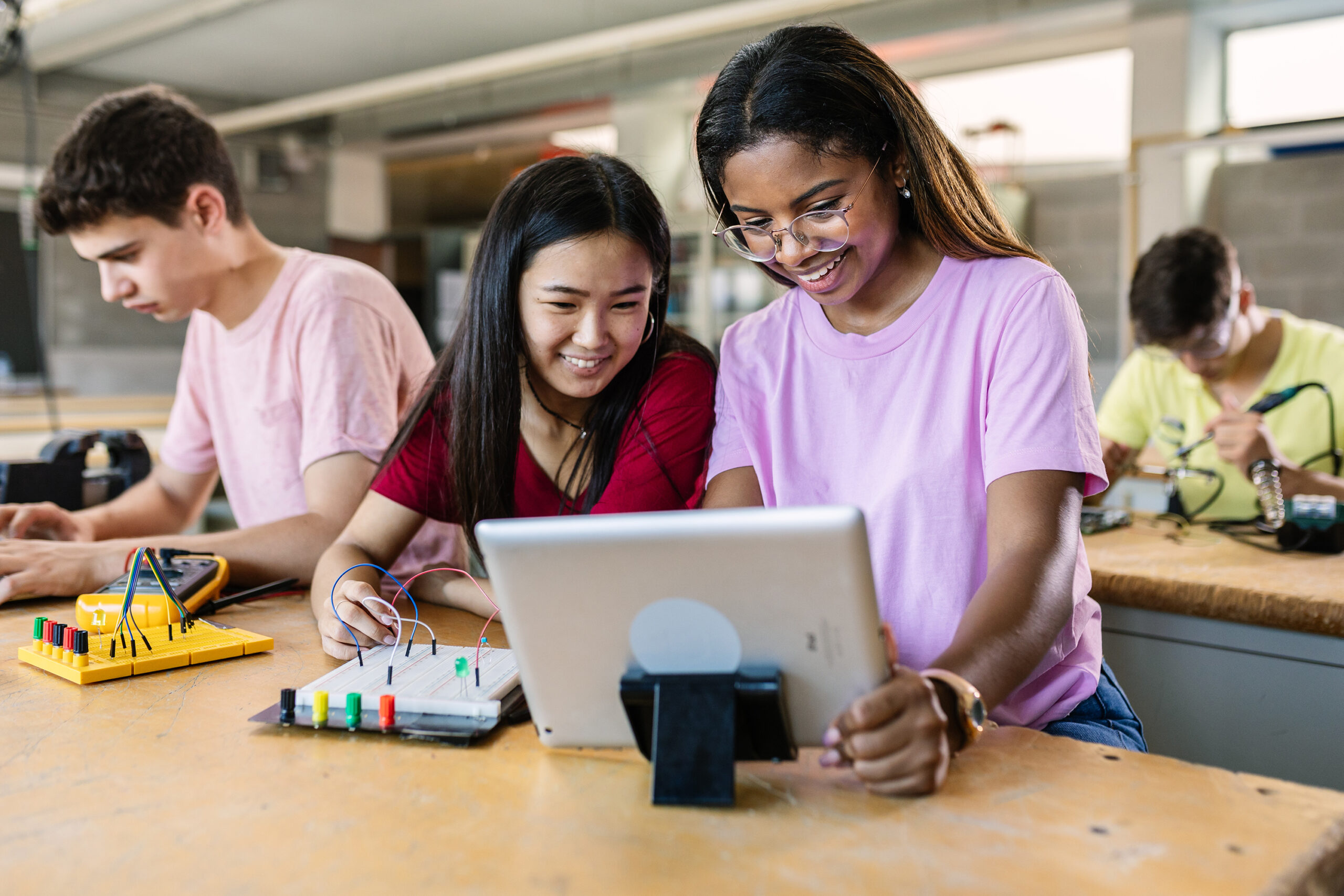 Group of diverse teenage students learning together to build electronic circuits